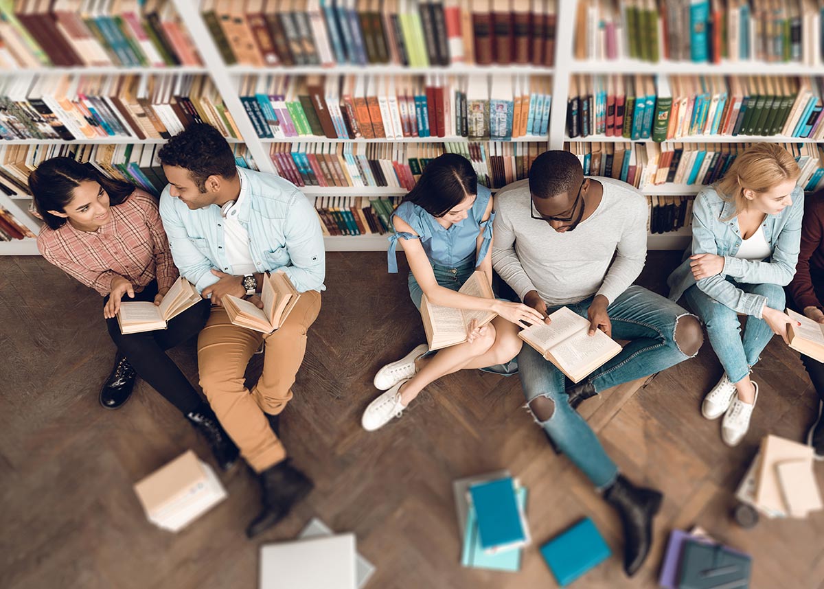 group of students reading on the floor of a library