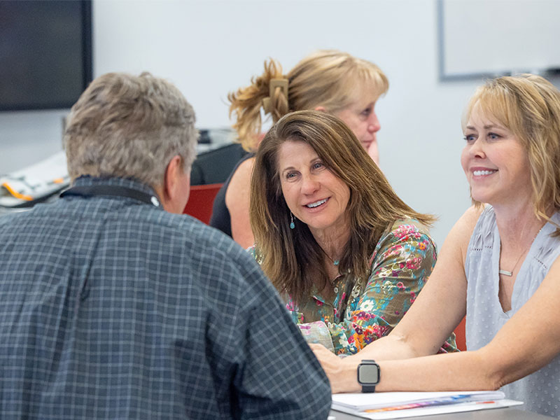Change Maker students talking together while sitting at a table