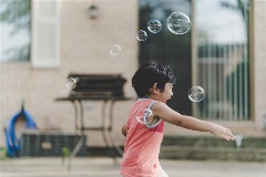 Child Playing With Bubbles