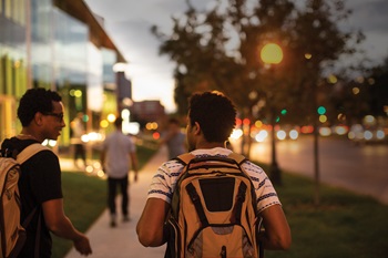 two male students walking by street
