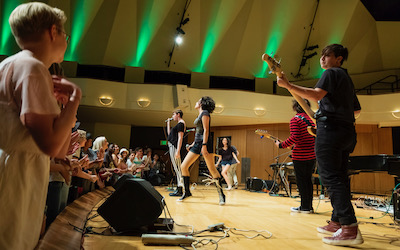 Kids playing instruments on stage