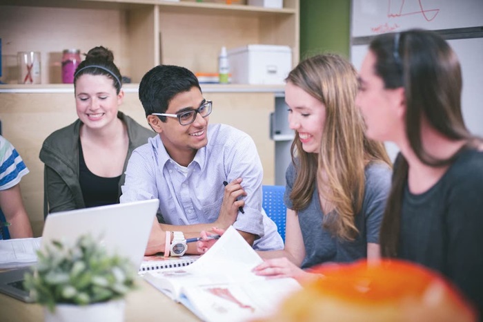 A group of students smiling and laughing in class.
