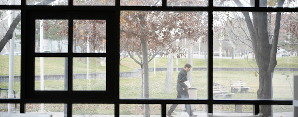 Man walking outside as seen through windows