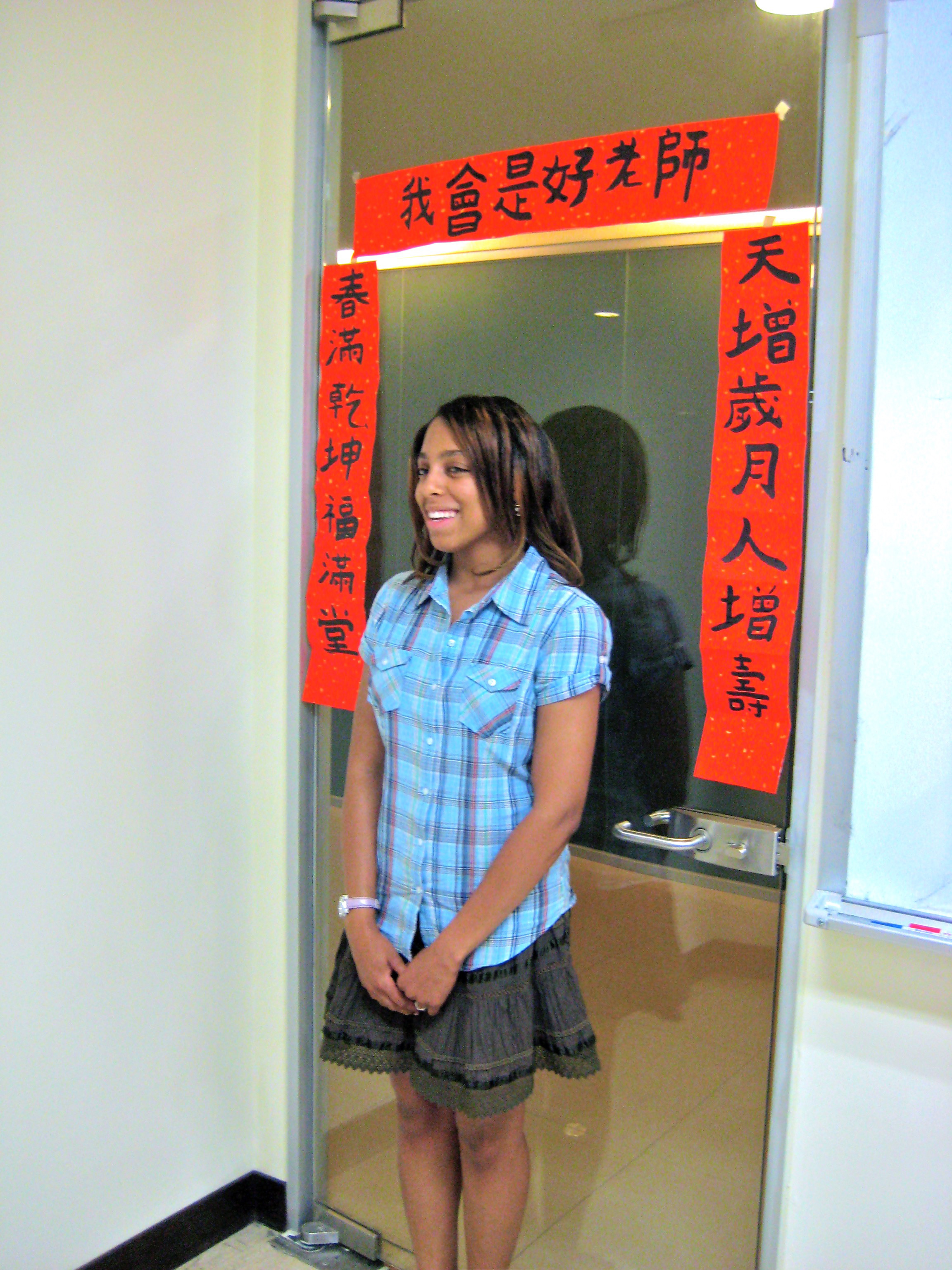 Krystal Booker-Reusch having her picture taken in front of Taiwanese text