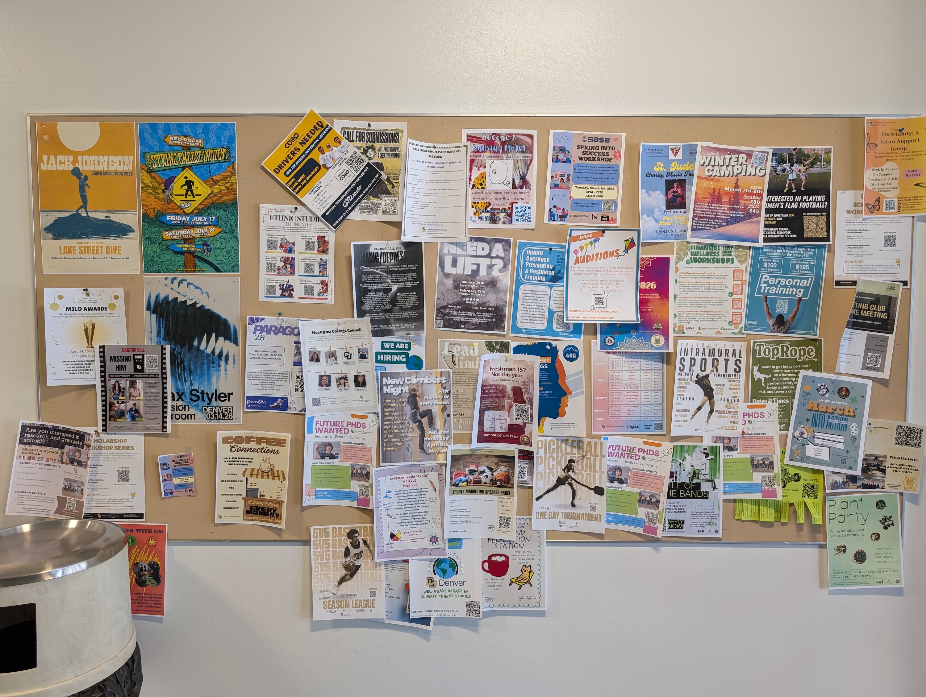numerous flyers tacked onto a cork board