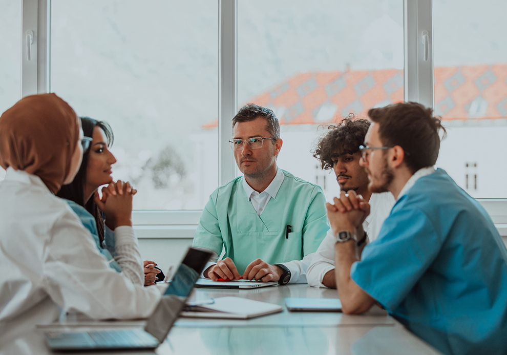 College professor and health sciences students in meeting room