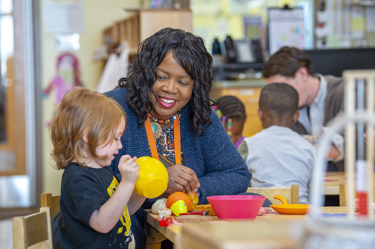 Image of Brenda Perry working with a small child in a classroom.