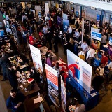 View from the ceiling of job fair booths and people moving about.