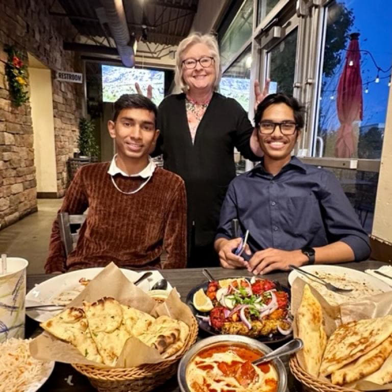 CU at the Table host with two international students at a meal.