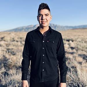 Joaquin Gallegos standing in a field in all black clothing