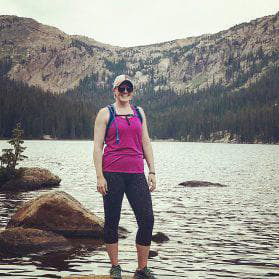 Kristen Freaney standing in front of a lake with mountains behind