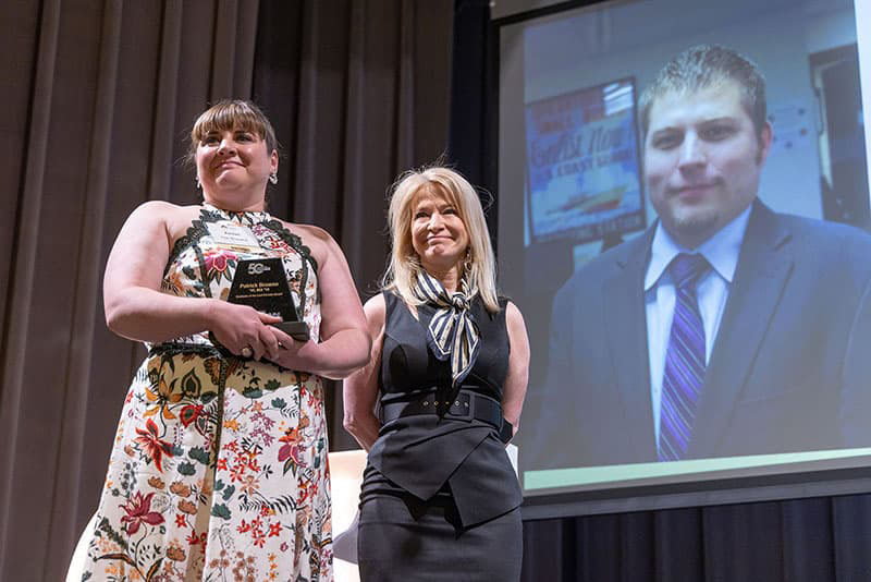 Chancellor Marks with Rachel Browne on stage with the alumni award.