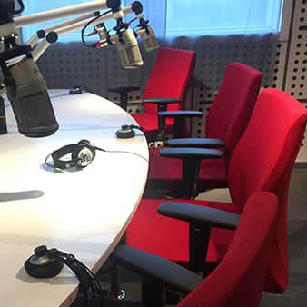 Recording studio with microphones and red chairs