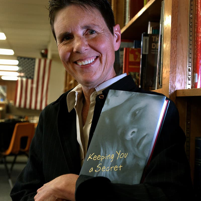 Julie Ann Peters holding her book "Keeping You a Secret."