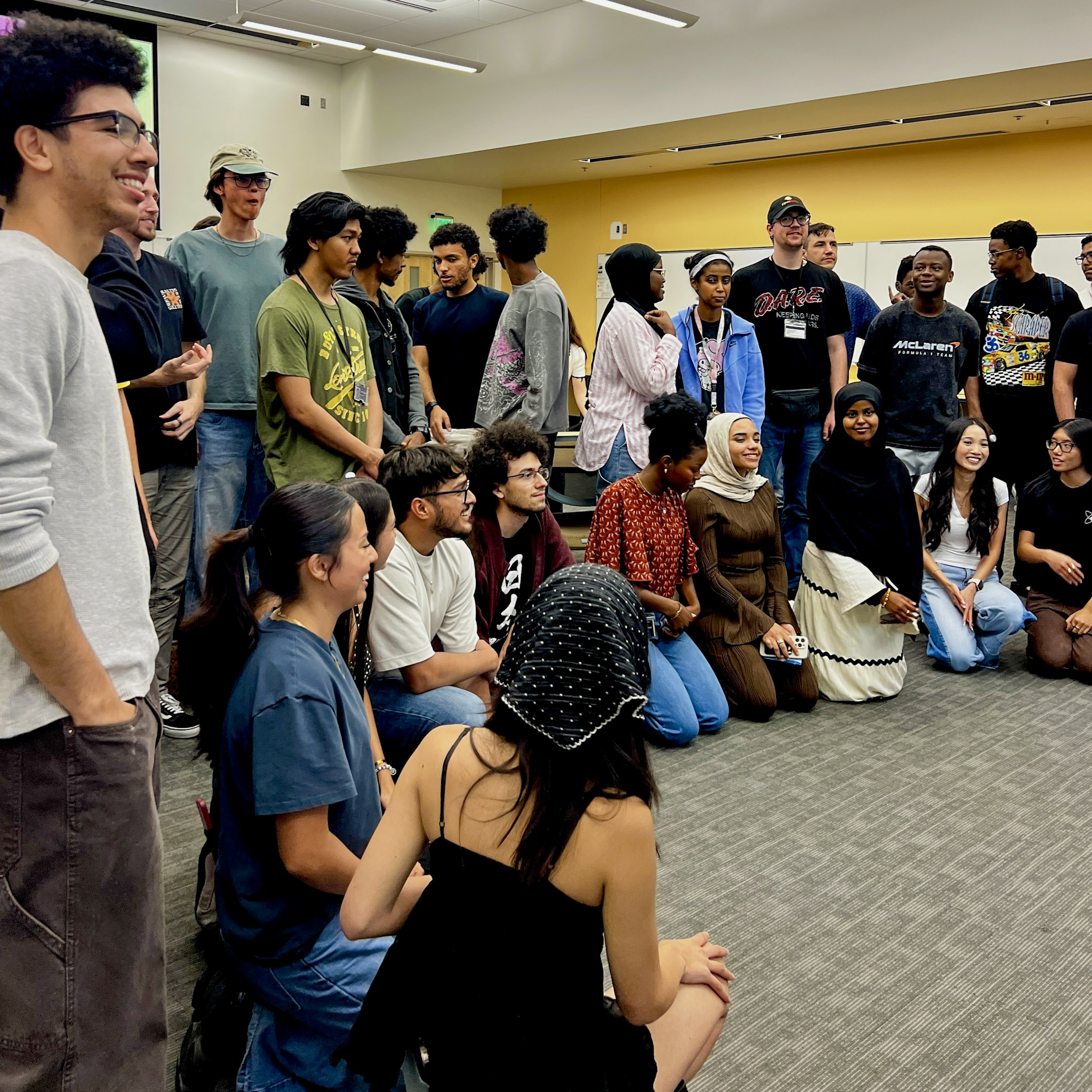 A big group of people gathered together and smiling for a group photo at the STEM Open House social event.