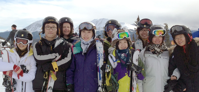 students posing at the top of a ski resort