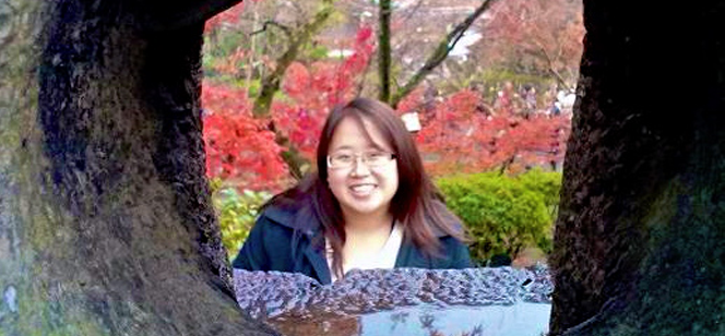 Stella Yuan posing between trees