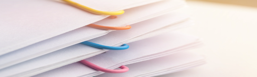 stack of paper with colorful paperclips