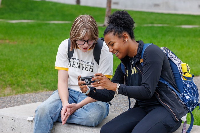 CU Denver students sharing a phone