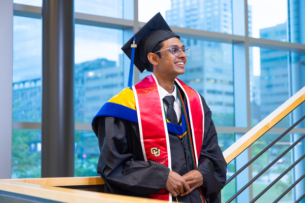 Student wearing regalia in student commons