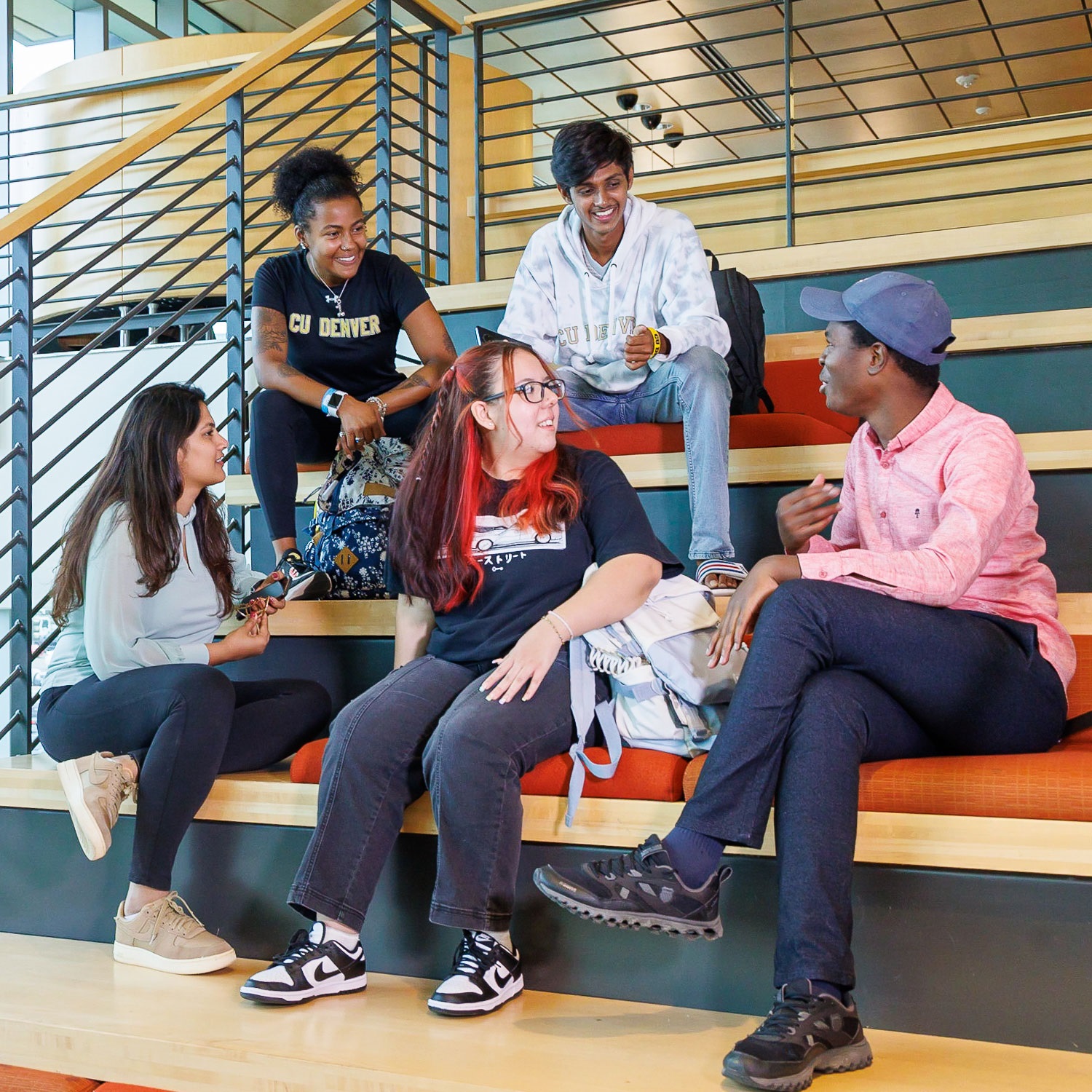 CU Denver students sitting down on stairs in student center while chatting