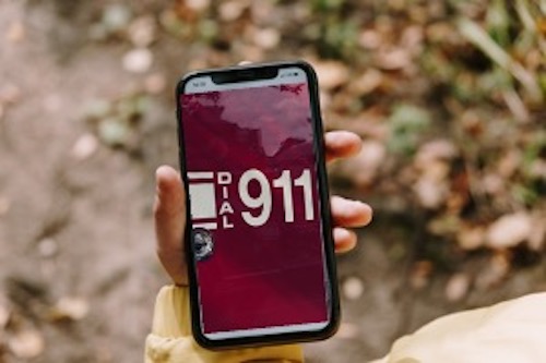Hand holding mobile phone showing dial 9-1-1 in an emergency