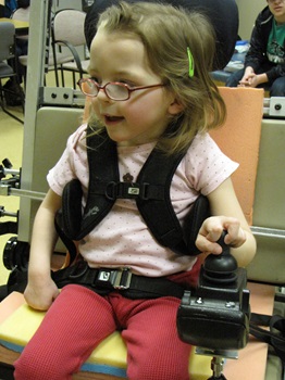 a young girl trials a new joystick for her power wheelchair