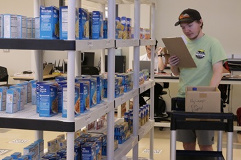 a research participant uses a novel prompting system to stock shelves