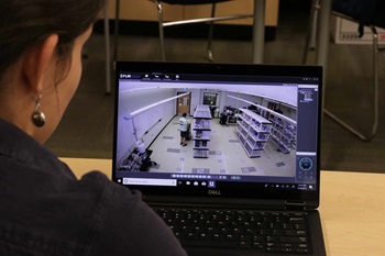 a graduate students monitors a video feed of a research session