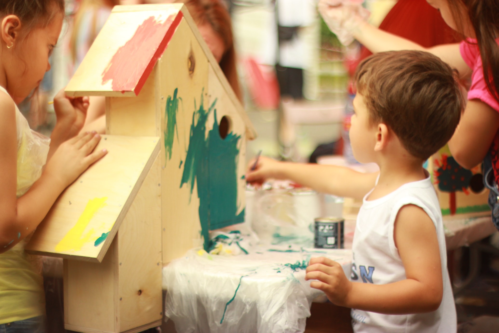 a young boy painting a birdhouse