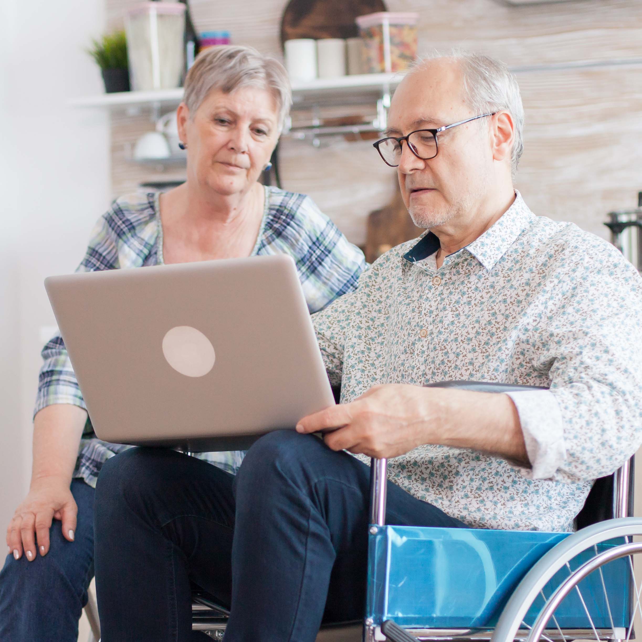 Older man in wheelchair with laptop