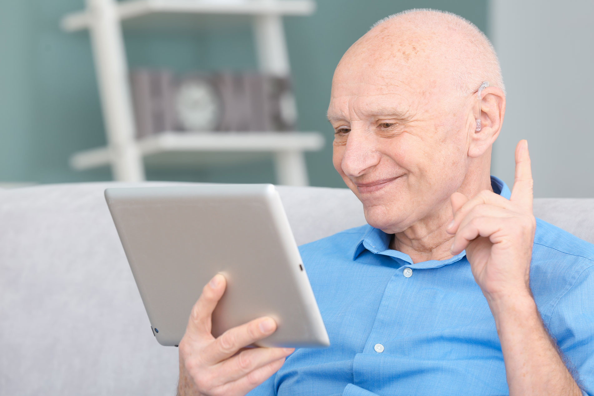Man with hearing aid uses tablet