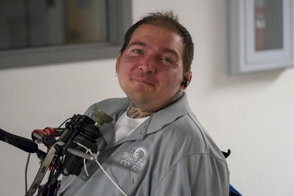 A gentleman poses with his chin drive wheelchair controller