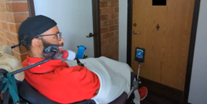 A person in a wheelchair uses his voice to unlock his door