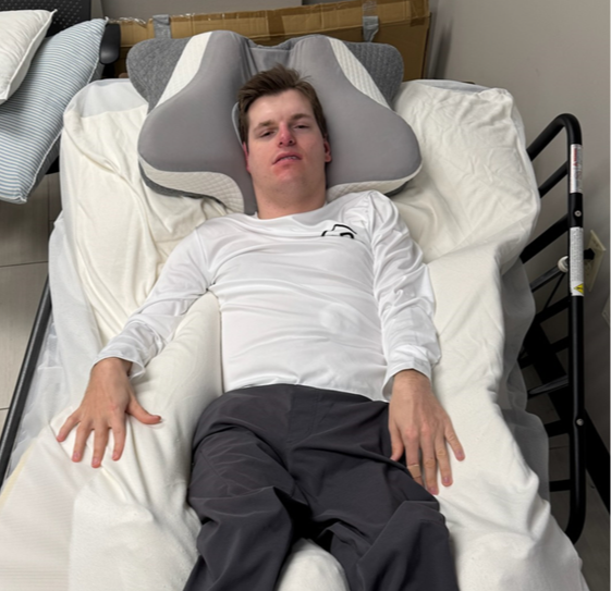 A young adult lays supported by clinically molded foam supports.