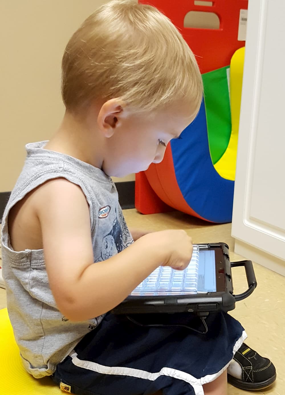 a young child uses his communication device