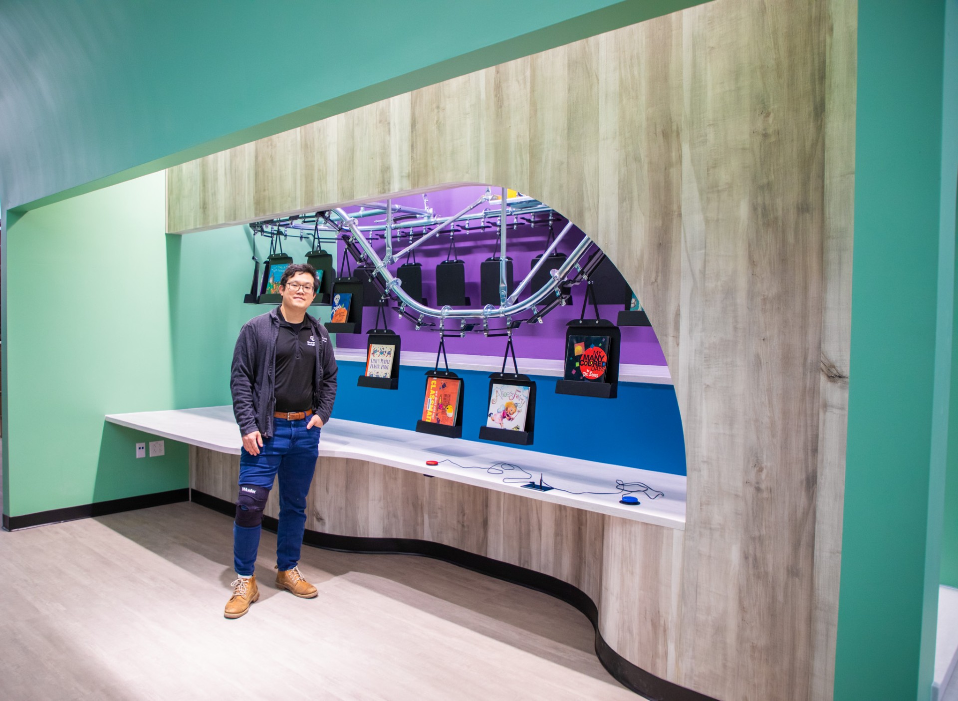 Morris Huang in front of new library conveyor system at Fletcher Miller School
