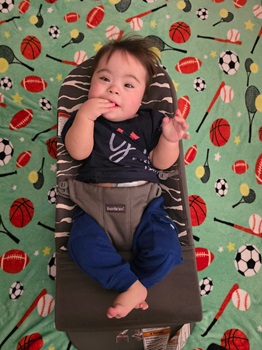 Young boy laying in a Bjorn Bouncer