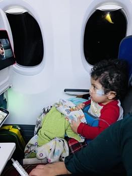 a child sitting on an airplane in the goto postural support seat
