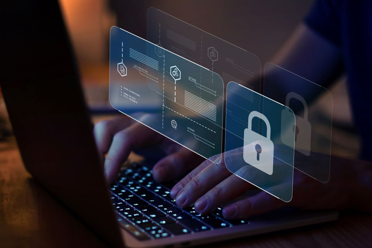 Image of hands on a keyboard with a cybersecurity lock over them.