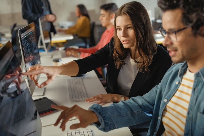 Image of two people working together at a computer.
