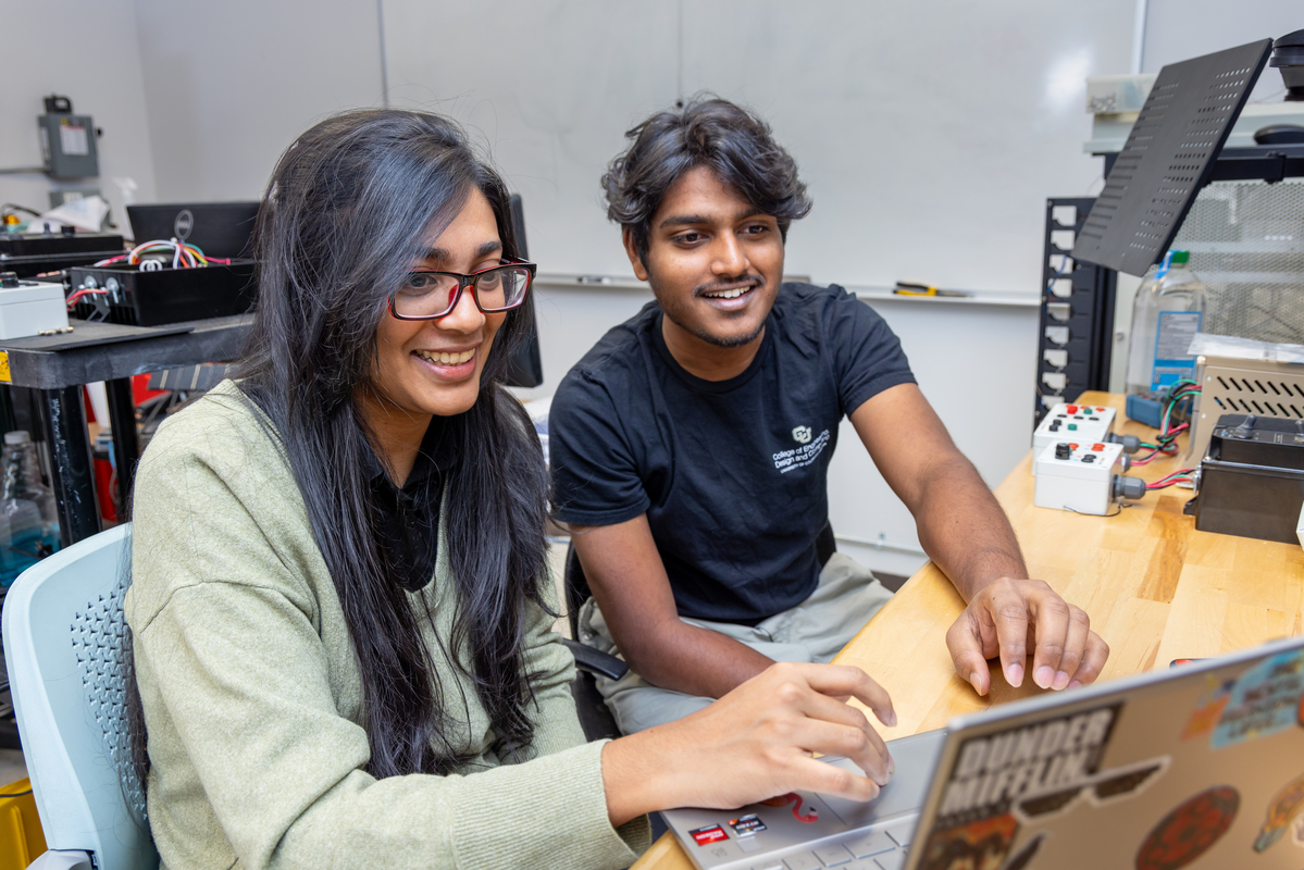 Two people looking at a laptop