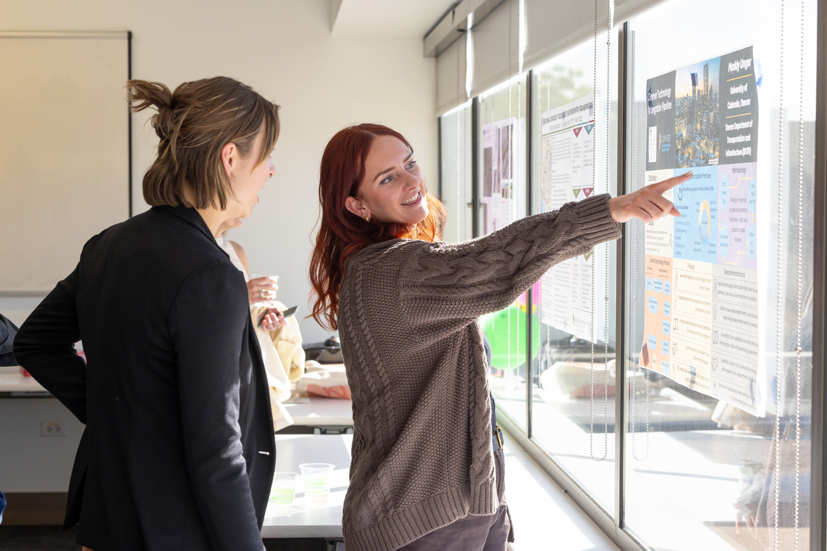 two women looking at a poster and discussing