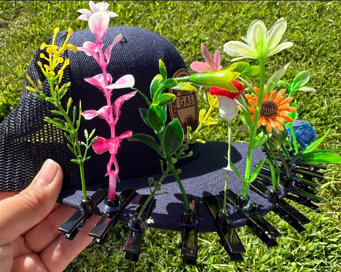 black baseball cap with rave sprouts pinned along the rim